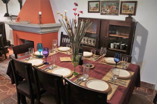 a dining room table with plates and wine glasses at Villas Santa Ana-Ricardo in Antigua Guatemala