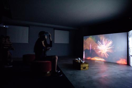 a person taking a picture of a fireworks display on a screen at Eaton HK in Hong Kong