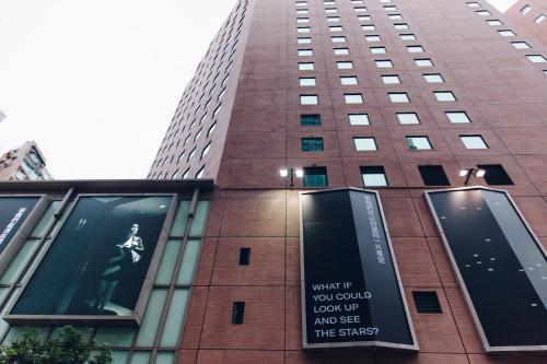 a tall building with a sign on the side of it at Eaton HK in Hong Kong