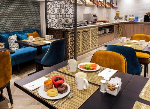 a restaurant with two tables with plates of food at Eurostars Puerta Real in Granada