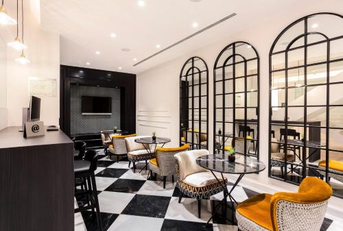 a restaurant with tables and chairs and windows at Eurostars Puerta Real in Granada