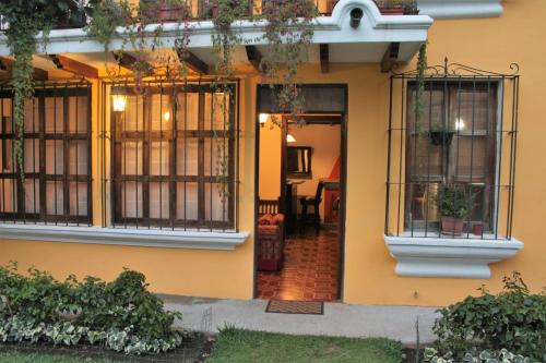 a yellow house with windows and plants on it at Villas Santa Ana-Ricardo in Antigua Guatemala