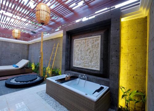a bathroom with a bath tub and a sink at Villa Bougainville in Seminyak