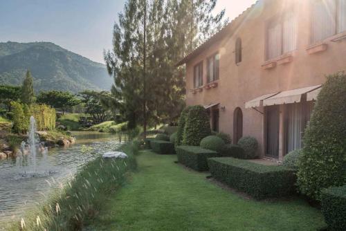 a house with a pond next to a building at Toscana Hotel La Casetta in Mu Si