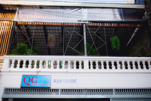a building with a white balcony with a row of plants at NK Guesthouse 2 in Bangkok