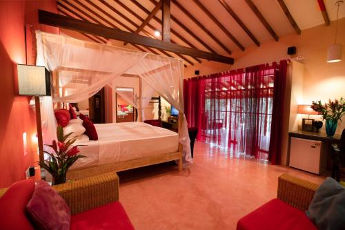um quarto com uma cama de dossel e 2 cadeiras em Dickman Resort "The Boutique Hotel" em Negombo