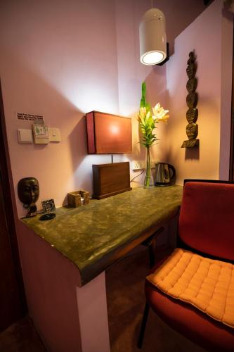 a room with a desk with a vase of flowers and a chair at Dickman Resort "The Boutique Hotel" in Negombo