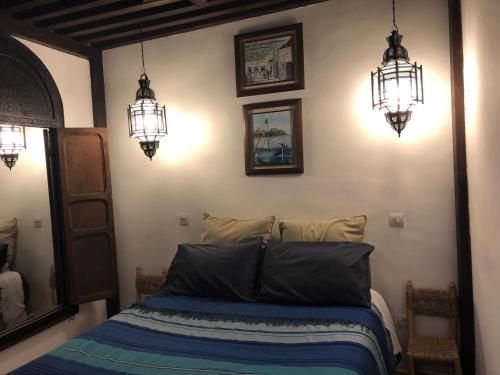 a bedroom with two chandeliers and a bed at Riad Marhaba in Rabat