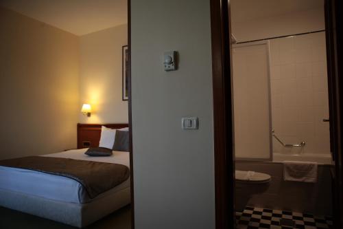 ティミショアラにあるサボイ ホテルのベッドルーム1室(ベッド1台付)、バスルーム(バスタブ付)が備わります。
