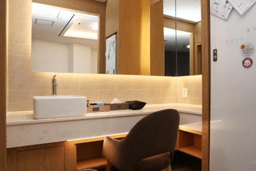 a bathroom with a sink and a mirror at Hotel Artheim in Gwangju