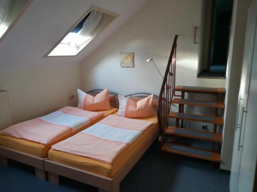 a bedroom with two beds and a stair case at Kyffhäuserhotel "Goldene Aue" in Wallhausen