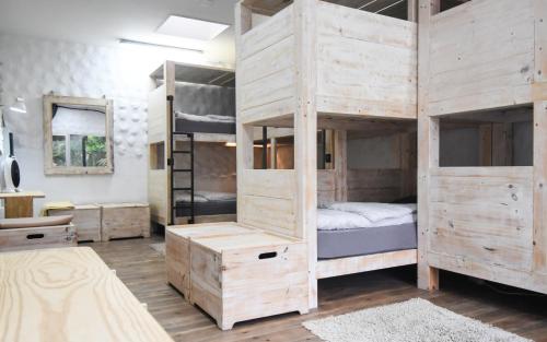 a room with two bunk beds and a bathroom at Wellenkind Surfschool in La Pared
