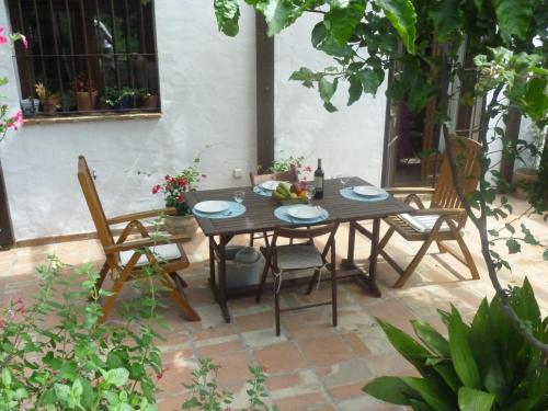 una mesa de madera y sillas en un patio en Camino del Castillo, en Jimena de la Frontera