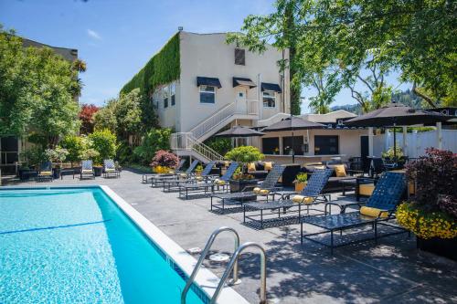 einen Pool mit Stühlen und Sonnenschirmen neben einem Gebäude in der Unterkunft Mount View Hotel & Spa in Calistoga