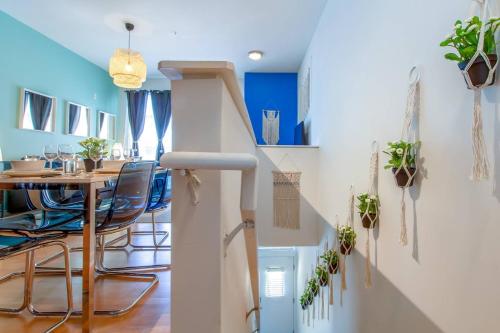 a room with a dining table and a staircase with plants at Trifecta 10 Min Walk to 7th St Market Superhost in Charlotte