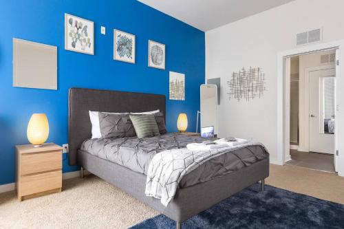 a blue bedroom with a bed and a blue wall at Trifecta Ace Location Pool & Gym Superhost in Charlotte