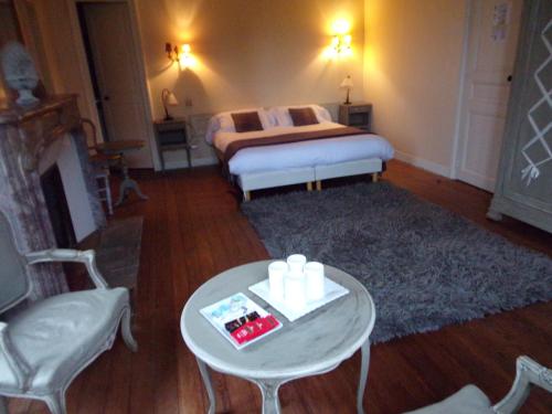 a living room with a bed and a table with a coffee table at Domaine de Bel Air in Cérans-Foulletourte