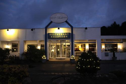 a building with a sign for a restaurant at night at Ebeltoft Park B & B in Ebeltoft