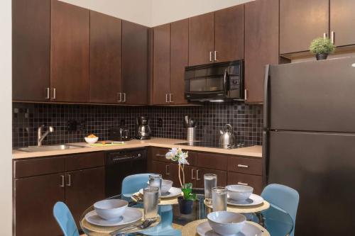 a kitchen with a table with chairs and a refrigerator at Trifecta 10 Min Walk to Epicentre Superhost in Charlotte
