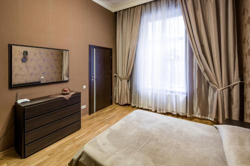 - une chambre avec un lit, une commode et une fenêtre dans l'établissement Svobody Avenue 10, à Lviv