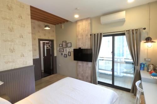 a bedroom with a white bed and a window at 看見七星潭民宿2064&2065 in Dahan