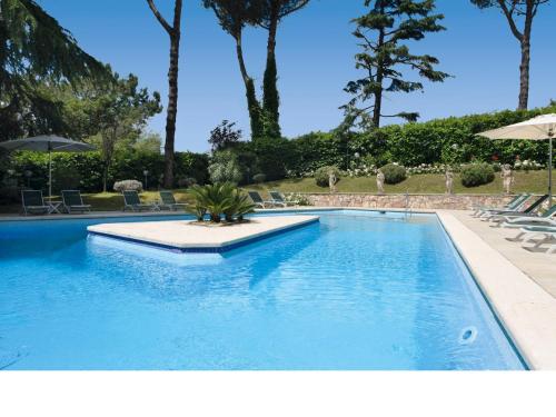 a blue swimming pool with chairs and umbrellas at Eurogarden Hotel in Rome