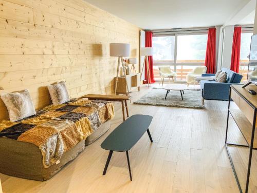 ムジェーヴにあるResidence Lesporting Ski – Megeve – АW201の木製の壁のベッドルーム1室、ベッド1台、リビングルームが備わります。