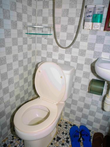 a bathroom with a toilet and a sink and blue shoes at Everest Hostel 14/F in Hong Kong