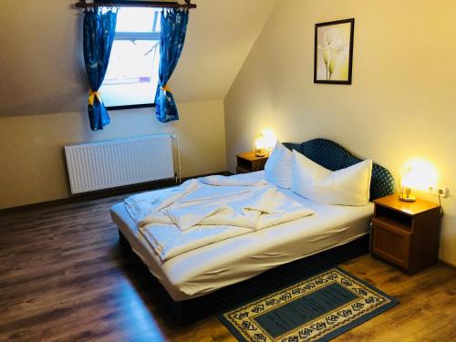 a bedroom with a bed and a window with blue curtains at Szűts Vendégház in Fertőrákos