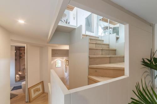 a staircase in a house with white walls and wood floors at Colosseum Exclusive Duplex in Rome