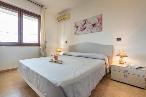 アルゲーロにあるAffittaSardegna-TRILO GEMELLI 4のベッドルーム1室(テーブル、ランプ2つ付)