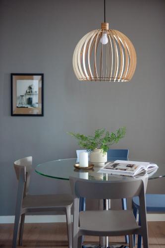 a dining room table with chairs and a pendant light at BJØRVIKA APARTMENTS, Opera Area, Oslo city center in Oslo