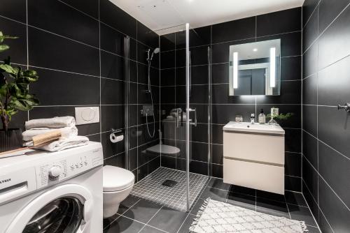 a bathroom with a toilet sink and a washing machine at BJØRVIKA APARTMENTS, Opera Area, Oslo city center in Oslo