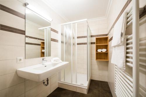 a white bathroom with a sink and a mirror at Knappensteig Appartements in Wagrain