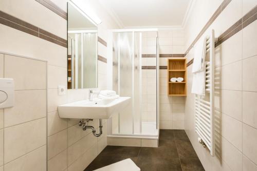 a white bathroom with a sink and a mirror at Knappensteig Appartements in Wagrain