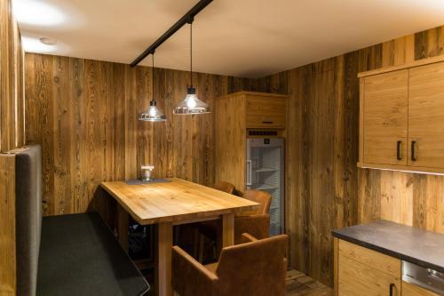 a kitchen with wooden walls and a wooden table at Knappensteig Appartements in Wagrain
