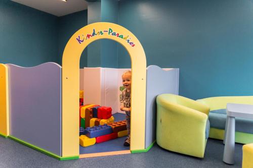 a child playing in a play room with a toy house at Knappensteig Appartements in Wagrain