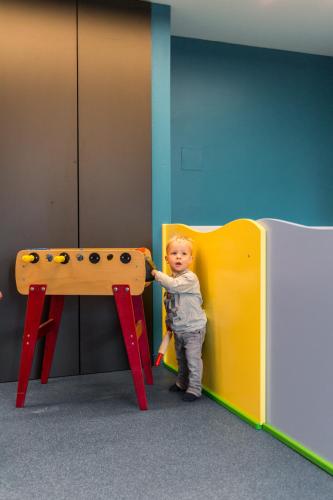 a young child is standing next to a play table at Knappensteig Appartements in Wagrain