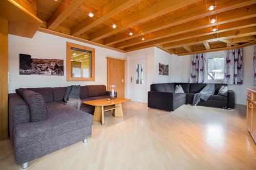 a living room with two couches and a table at Knappensteig Appartements in Wagrain