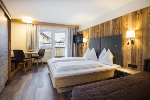 ein Hotelzimmer mit einem großen Bett und einem Schreibtisch in der Unterkunft Knappensteig Appartements in Wagrain
