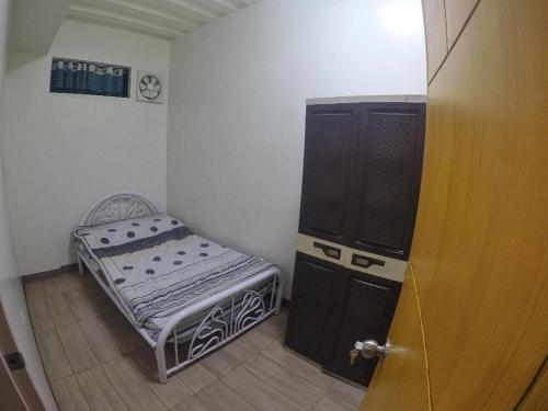 Habitación pequeña con cama pequeña y puerta en Modern Apartment 301 en Dagupan