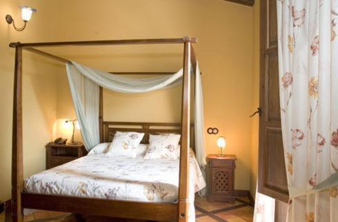 a bedroom with a canopy bed with two night stands and two lamps at Hotel Restaurante Font Salada in Oliva