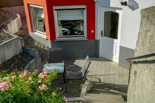 une terrasse avec 2 chaises, une fenêtre et une porte dans l'établissement Ferienwohnung Roth, à Frickingen