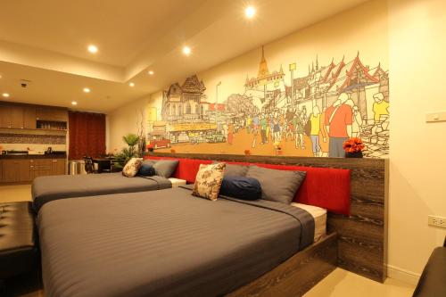 two beds in a room with a mural on the wall at Serena Sathorn Suites in Bangkok
