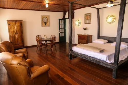1 dormitorio con 1 cama, mesa y sillas en GUARATIBALI RESIDENCE, en Barra de Guaratiba