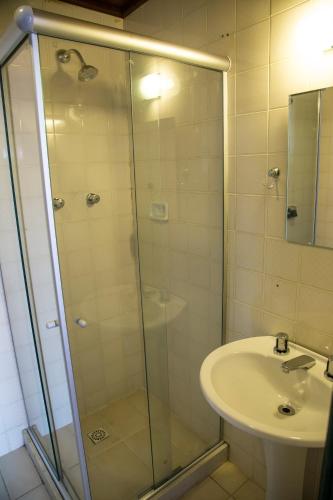 a bathroom with a glass shower and a sink at Jardim da Marambaia in Barra de Guaratiba