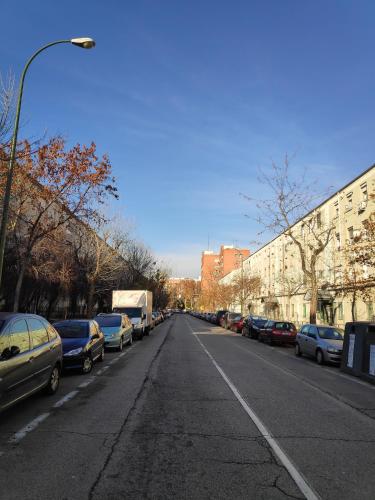 een lege straat met auto's aan de kant van de weg bij 16 Mirasierras in Madrid