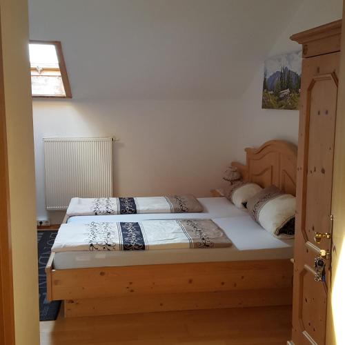 a bedroom with two beds and a window and a door at Lenggrieser Hof in Lenggries