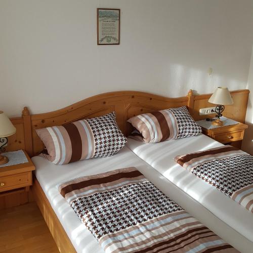 two twin beds in a bedroom with two lamps at Lenggrieser Hof in Lenggries