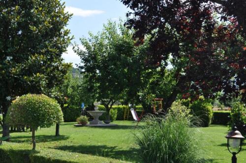 a park with a bench and trees and a fountain at Agriturismo Il Girasole Assisi in Assisi